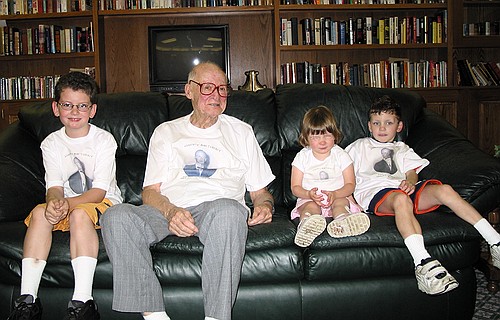 Great Gandpa poses with the three great grandkids