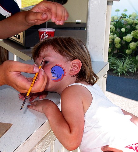 Jay gets a dinosaur painted onto her face