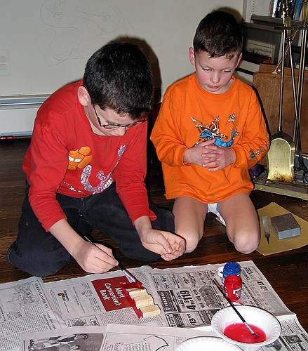 Jennifer watches Joe paint his Pinewood Derby car