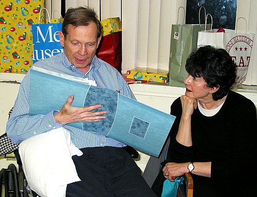 Papa, recovering from his fall, reads from the Anniversary book while Grandma listens