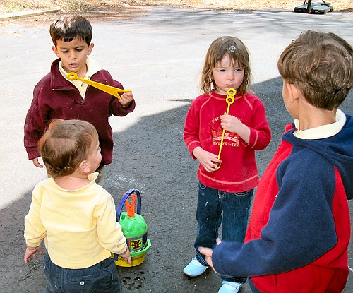 The kids blow bubbles in the driveway