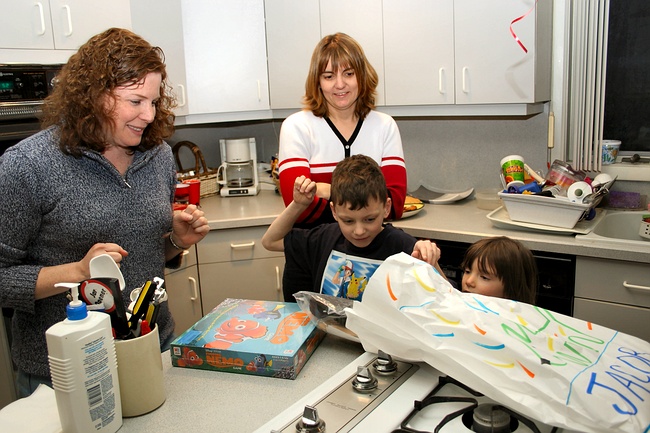 Jennifer cautiously opens a birthday present from Uncle Jonathan